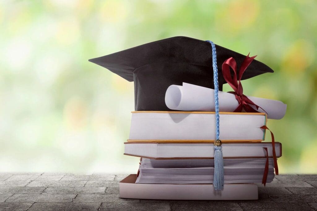 A stack of books with a graduation cap on top.