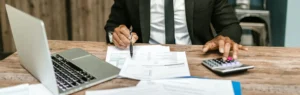 A person sitting at a table with papers and pens.